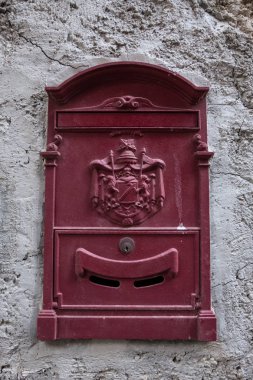 Arka planda kaba beton duvar ile kırmızı posta kutusu.