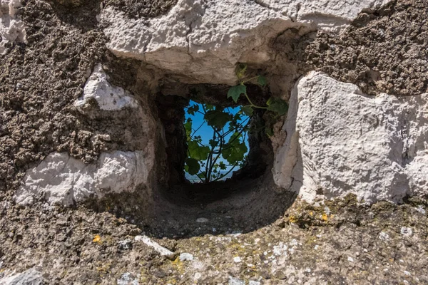 Natureza de um buraco quadrado de uma parede de pedra antiga . — Fotografia de Stock