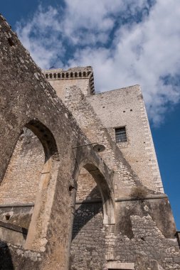Mavi gökyüzü ve bulutlar artalanla kemerler eski bir taş castle.