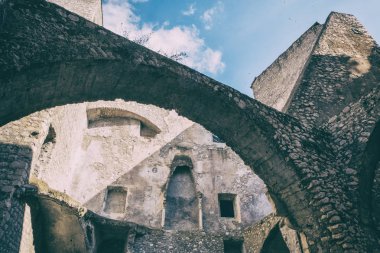 Kemerli bir Ortaçağ taş Kalesi mavi gökyüzü arka plan ile düşük açılı görünümü.