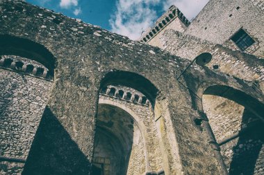 Mavi gökyüzü ve bulutlar arka plan ile eski bir kalenin kemerler.