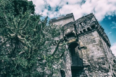 Bulutlar ve mavi gökyüzü arka plan ile bir taş castle yakınındaki doğa yükselir.