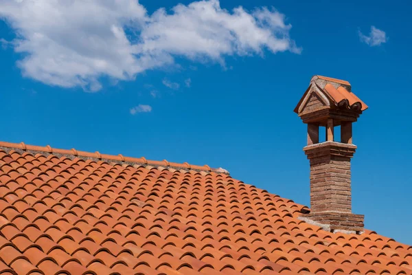 Turuncu kiremit çatı baca ile.