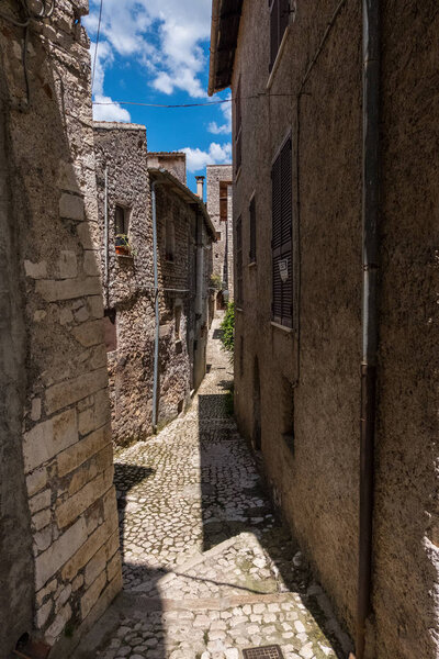 View of an alley with houses of the ancient stone made medieval town of Sermoneta, Italy. No people.