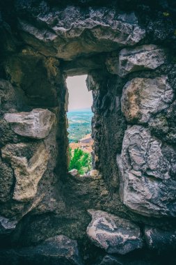 Eski bir taş duvar ince güvenlik penceresinden manzara.