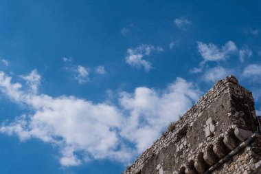 Mavi gökyüzü arka plan ile ayrıntılı eski yıpranmış taş castle.