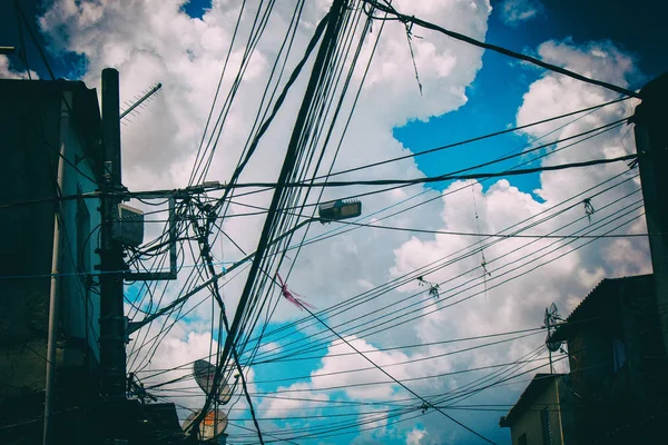 Fili elettrici e tv in una favela con cielo azzurro e nuvole sullo sfondo . — Foto Stock