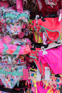 Colorful bikinis on a display. Clothes stall in the market. A rack of women's swimwear. No people. clipart
