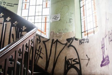 Grafiti duvarlara ve vitray pencereler ile terk edilmiş bir vintage evde kömür ahşap merdiven arka planına duvar kağıdı. Hiçbir insan.