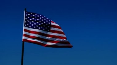 Amerikan, ABD, bayrak rüzgar mavi gökyüzü arka plan ile bir güzel parlak güneşli yaz gününde üfleme.