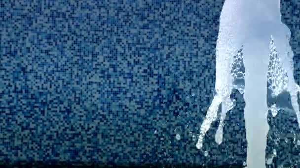 背景の壁にブルーの小さな正方形のタイルと噴水の瞑想水のしぶき — ストック動画