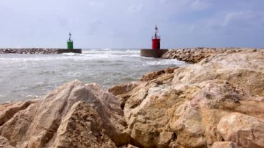 Deniz suyu geçerli ve yeşil fener kulesi ile liman erişim dalgalar bir dalga Emanet bariyer kayalardan görüntülendi?.