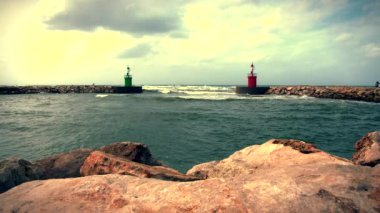 Deniz suyu geçerli ve yeşil fener kulesi ile liman erişim dalgalar bir dalga Emanet bariyer kayalardan görüntülendi?.
