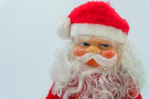 Beyaz arka plan üzerinde izole elinde gümüş bir çan ile Noel Baba oyuncak figür.