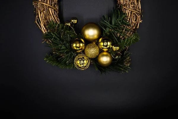 Duvar kağıdı arka plan doku Noel çelenk yeşil dallar siyah arka plan üzerine izole dal ve altın top ve süslemeler yapılmış.