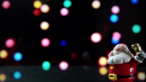 圣诞老人玩具与圣诞节五颜六色的设计灯在背景在晚上 剪辑镜头准备循环与圣诞树透明球或小面包与问候文本圣诞快乐和新年快乐 — 图库视频影像