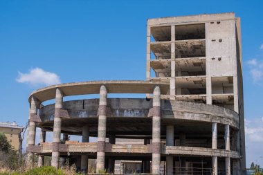 Büyük çok katlı beton yapı terk edilmiş binanın merdiven çim ve ağaçların içinde belgili tanımlık geçmiş mavi gökyüzü ile çevrili ile. Mimari detay. Hiçbir insan.