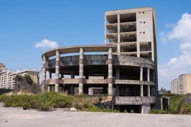 Büyük çok katlı beton yapı terk edilmiş binanın merdiven çim ve ağaçların içinde belgili tanımlık geçmiş mavi gökyüzü ile çevrili ile. Mimari detay. Hiçbir insan.