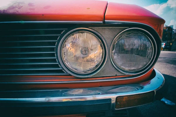 Ayrıntı görünümü ön kırmızı eski model araba tampon ve ışıklar. Klasik duvar kağıdı arka plan görüntüsü. Hiçbir insan.