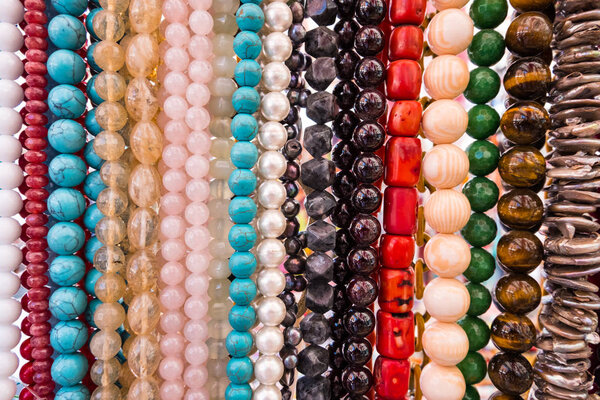 Wallpaper background of colorful necklace made of gemstones and colored beads showcased in a shop. Semi precious jewelery.