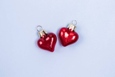 Pastel mavi arka plan yansıtır ile güzel dekoratif kırmızı cam kalpler. Sevgililer Günü Konsepti.