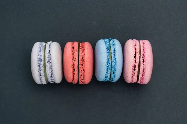 Gri arka planda güzel renkli macaroons. Yatay renkli görüntü. Üstte görüntü.