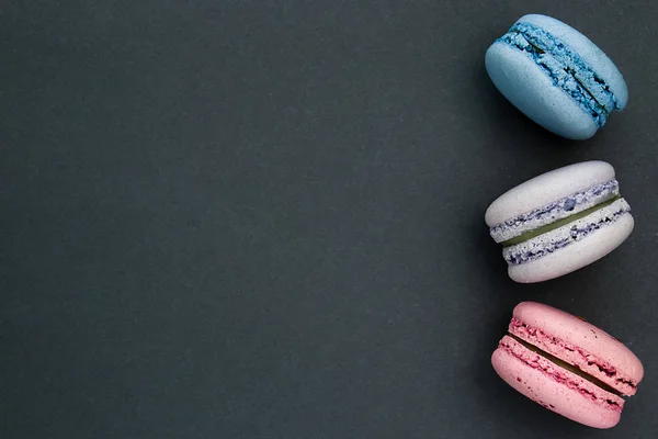 Koyu gri arka plan üzerinde Macaroons. Metin için yer. Şenlikli konsept.