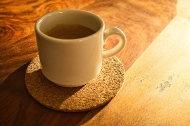 Düşük güneş ışığında ahşap bir tabak üzerinde espresso fincan. Metin için Yerleştir