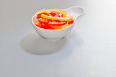 Sağlıklı bir yemek için malzemeler. Küçük bir seramik kasede dilimlenmiş Paprika.