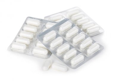 Beyaz arka planda izole blister paketi yakın çekim kapsül hapları.