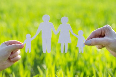 Kağıt adam aile yeşil çimenlerin üzerinde gösterilen womans götürdü eller yakın çekim