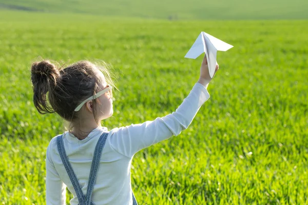 Happy kid playing with paper airplane