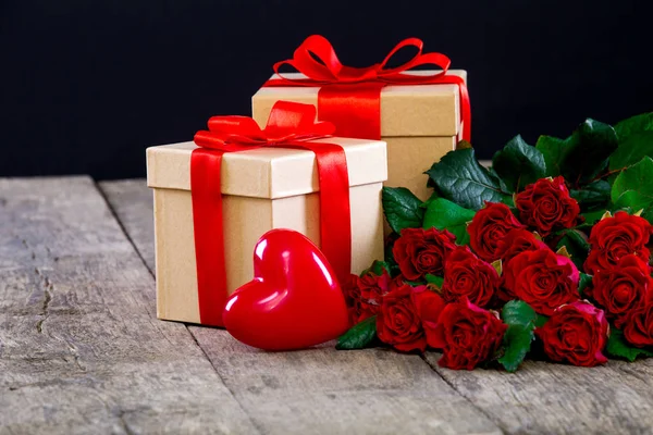 Καρδιές Και Ένα Μπουκέτο Κόκκινα Τριαντάφυλλα Στον Ξύλινο Πίνακα Φόντο — Φωτογραφία Αρχείου