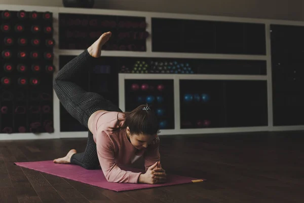 Spor salonunda eğitim kadın. Kapalı eğitim sportif genç kız. Sağlıklı bir kadın fitness mat bir spor sağlık merkezinde egzersiz yaparak. Fitness erkek eğitimi spor kulübü.