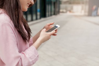 Bir kızın adresini bulmak için cep telefonu online haritalar kullanarak kırpılmış. Smartphone tarama ve online alışveriş yaparken tutan eller. Kadın kişi manifatura cep telefonu.