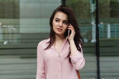 Meşgul kadın Yöneticisi dışında hücre telefon ile cep telefonu ile konuşurken ve şehrin sokak, uzaktan çalışma ve telefon yolu ile modern smartphone açık havada Yöneticisi üzerinde yürüyen bir kadın arıyorum