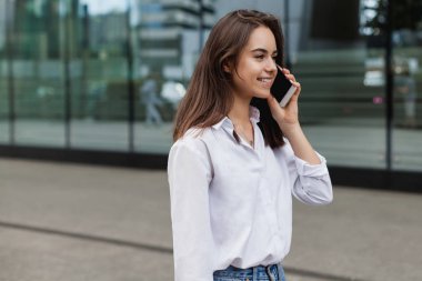 Meşgul kadın Yöneticisi dışında hücre telefon ile cep telefonu ile konuşurken ve şehrin sokak, uzaktan çalışma ve telefon yolu ile modern smartphone açık havada Yöneticisi üzerinde yürüyen bir kadın arıyorum