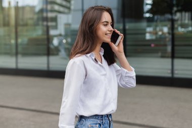 Uzaktan telefon cep telefonu ile konuşurken ve sokak, şehirde kadın girişimci yönetme iş gülümseyen mutlu başarılı işkadını dışında hücre telefon ile arama yapma