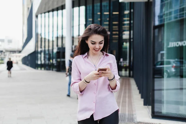 Ofisinin, telefon tarama ve online bir mobil uygulaması alışveriş merkezi yürüyüş gülümseyen süre alışveriş yaparken güzel kadın cep telefonu kullanan mutlu oldukça esmer kız. Online iletişim.