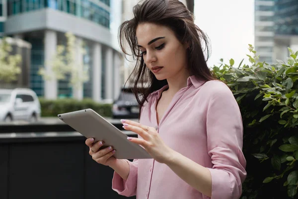 Konsantre Yöneticisi kız taşınabilir dokunmatik yüzey haber tarama için kullanıyor. Pozitif öğrenci okuma dijital tablet iş makaleler dersleri önce koyu saçlı. Kadın besleme kaydırma