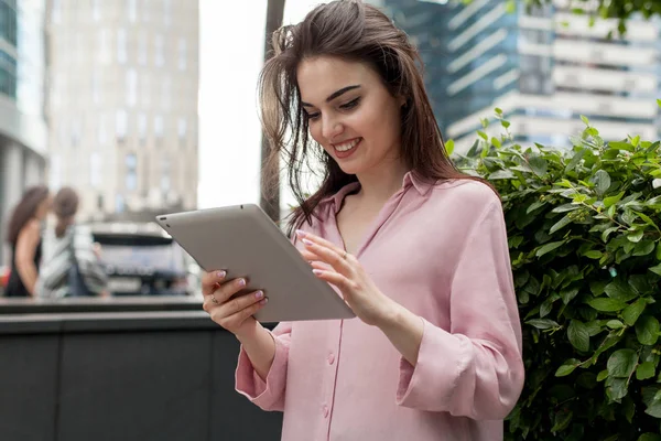 Mutlu kız dijital tablet komik videolar izliyor. Genç profesyonel online dersler dokunmatik yüzey üzerinde izlemek ve yorum video altında yazma mutludur. Sosyal sayfalar bir yem kaydırma kız.