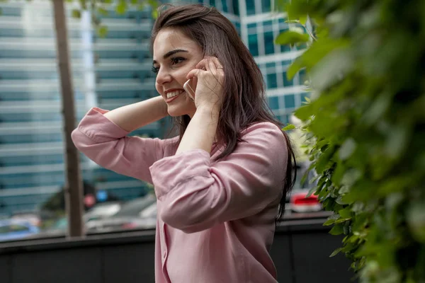 Mutlu başarılı işkadını dışında gülümseyen kadın girişimci smartphone sohbet esmer güzel kız cep telefonu ile konuşurken hücre telefon ile arama portresi