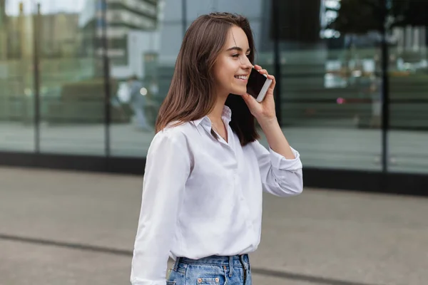 Uzaktan telefon cep telefonu ile konuşurken ve sokak, şehirde kadın girişimci yönetme iş gülümseyen mutlu başarılı işkadını dışında hücre telefon ile arama yapma