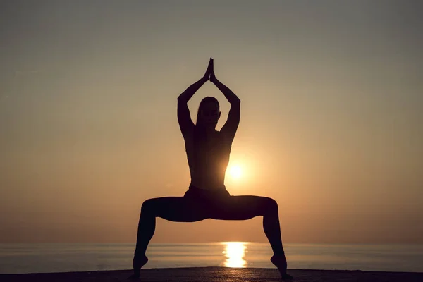 Meditasyon pratik sakin kumsalda gündoğumu yaz tatili sırasında sabah, İspanya'da ise bir yoga poz duran bir kadın silueti görünümünde nadir. Sağlıklı yaşam tarzı ve gevşeme.