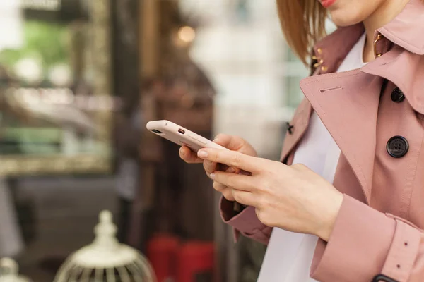 Kadın cep telefonu ile online alışveriş, iş kadını için internet tarama görünümünü kırpılmış genç kızın cep telefonu şehir, sokak, tutan eller, modern smartphone aygıtı kullanarak görüntüyü kapat