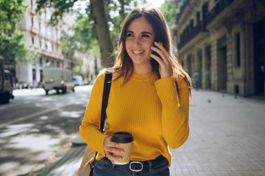 Akıllı telefon cihazıyla konuşurken gülümseyen genç, pozitif kadın, dışarıda cep telefonunu kullanan çekici İspanyol kız.
