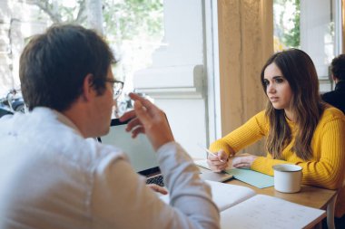 Çekici erkek ve kadın serbest çalışanlar multimedya paylaşıyor ve onunla iyi iş çıkarmayı tartışıyorlar. Teknoloji projesi, ortaklar laptopla işbirliği yapıyor.