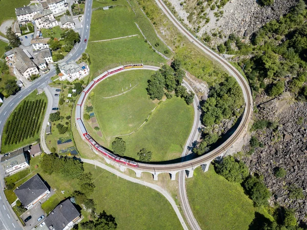 Brusio スイス連邦共和国 2018 Brusio グリソン州スイス アルプスで有名な円形の高架橋からベルニナ急行が起こって このスパイラル Viadukt はユネスコの文化遺産 1908 — ストック写真
