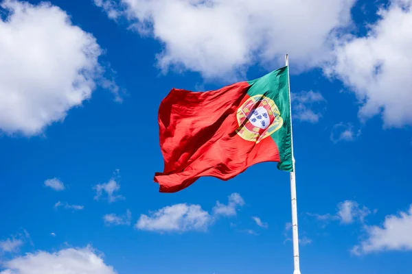Португальский Национальный Флаг Размахивая Ветру Против Синего Солнечного Неба Белыми — стоковое фото