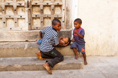 Stone Town, Tanzanya - 27 Eylül 2012: iki küçük Afrikalı çocuk sokakta kendi kardeşi bakımı. Afrian ülkelerdeki genç çocuklar erken yaşta aile onların günlük yaşam yardım etmelisin.